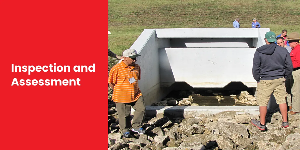 Inspection and Assessment Group of people inspecting a concrete drainage structure with rocky surroundings